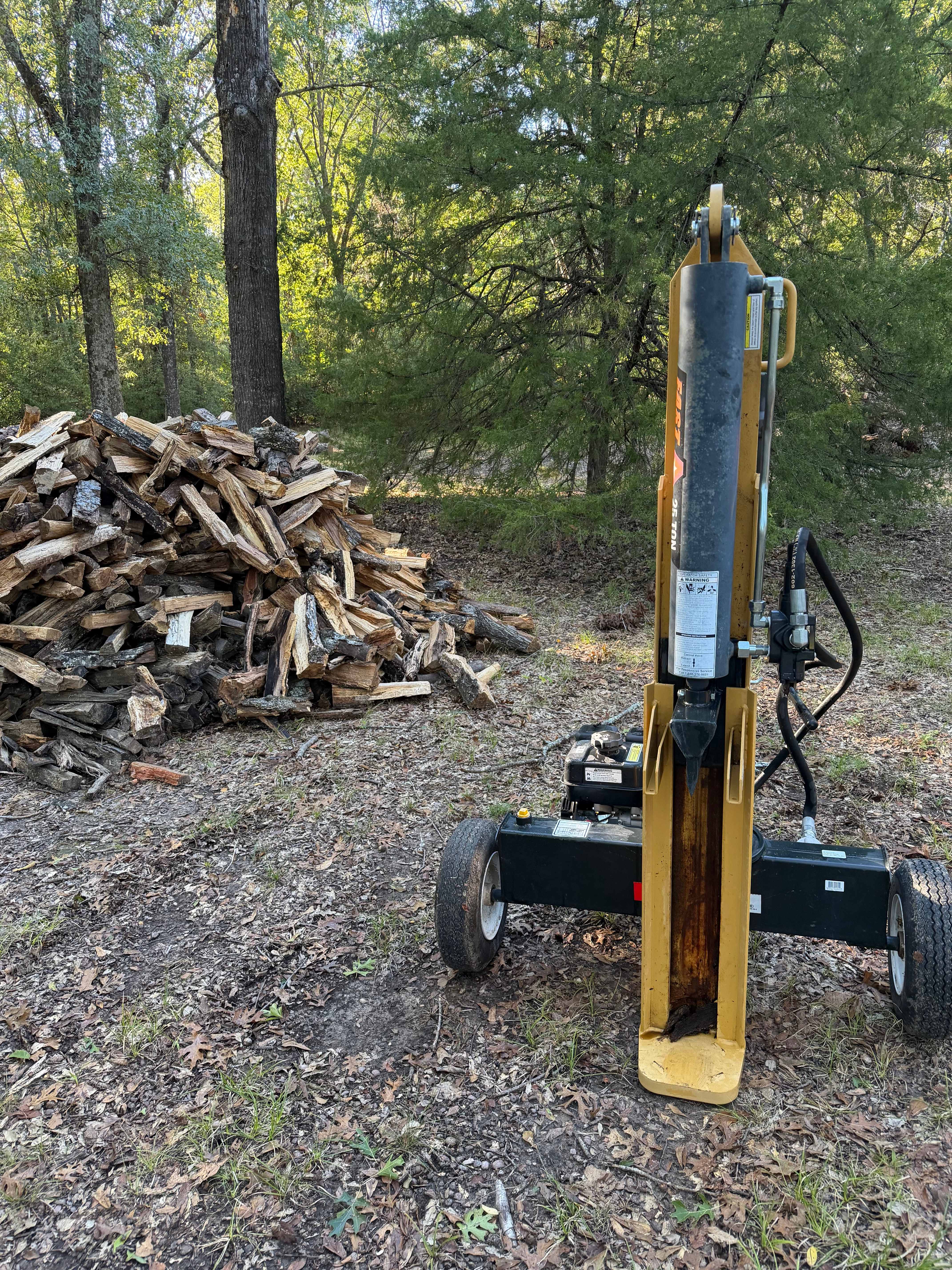 CountyLine 25 ton gas log splitter beside a pile of split firewood — equipment rental in Kemp TX